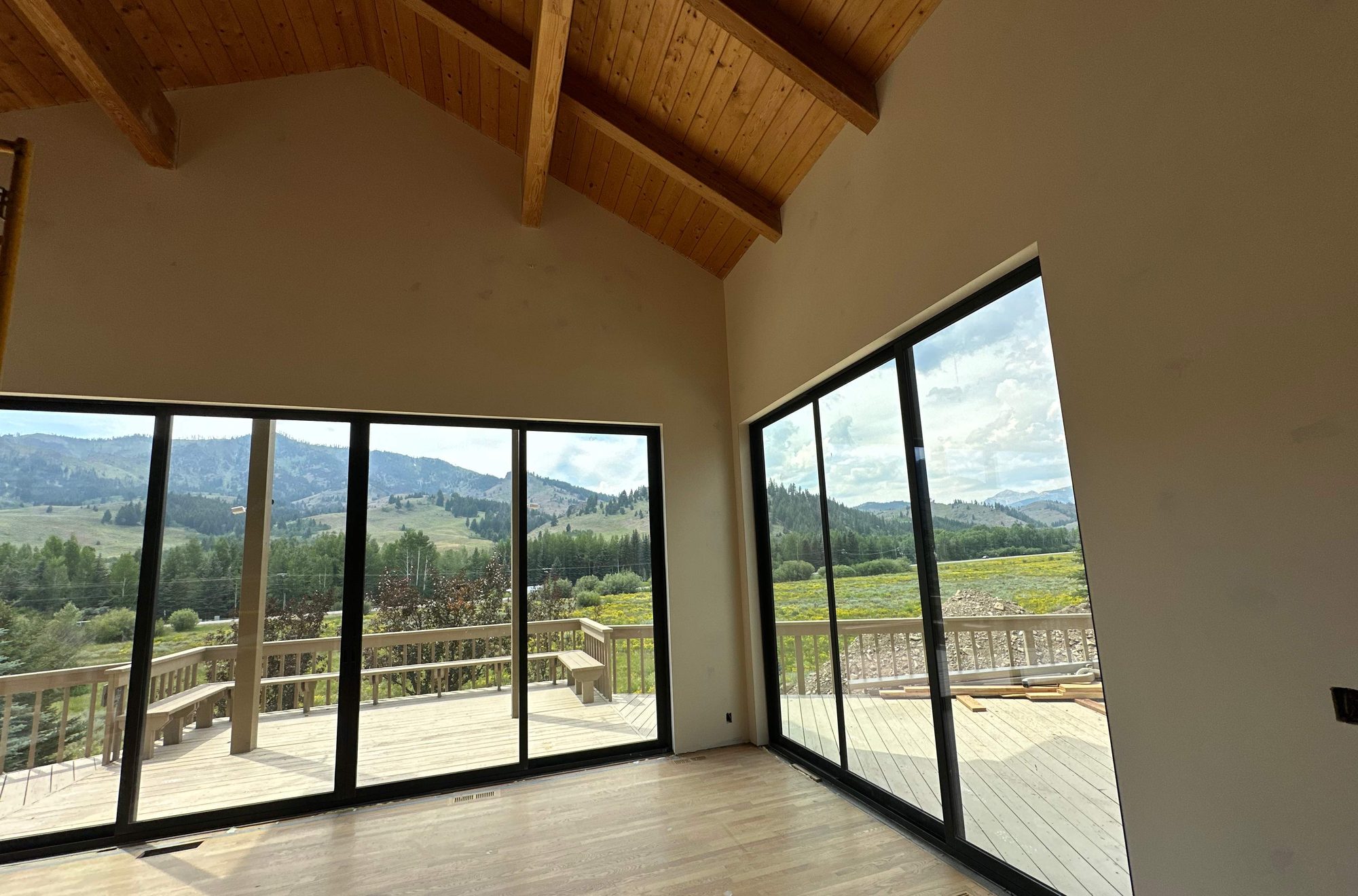 A wall of glass doors opening to the mountains